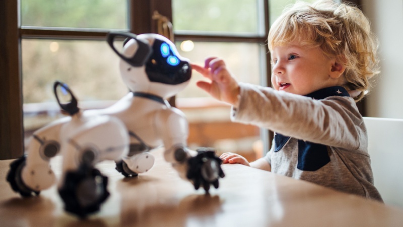 Bambino con gioco cane robot